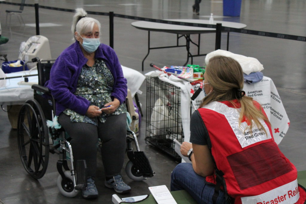 Kathie Tapia speaks with a Red Cross volunteer at the  Oregon Convention Center after being forced from her home due to wildfires in Clackamas County, Oregon. Photo by Axl David/American Red Cross.