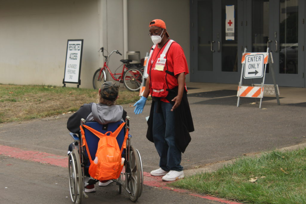 American Red Cross volunteer Michael Watkins speaks to a guest visiting the Red Cross shelter at the Oregon State Fairgrounds in Salem, Oregon on Tuesday, Sept. 15, 2020. Photo by Axl David/American Red Cross.