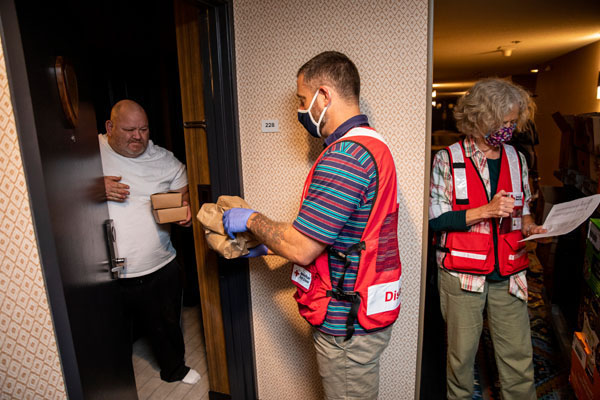 Jeff Pyle receives a meal from American Red Cross volunteer Roger Brubaker, at a hotel that is being used by the American Red Cross as a shelter for evacuees from the Oregon wildfires in, Eugene, OR