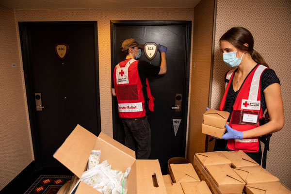 American Red Cross volunteers Grace Proudfoot, right, and Kalen Pippins, deliver meals to evacuees from the Oregon wildfires at a hotel that is being used by the American Red Cross as a shelter in, Eugene, OR