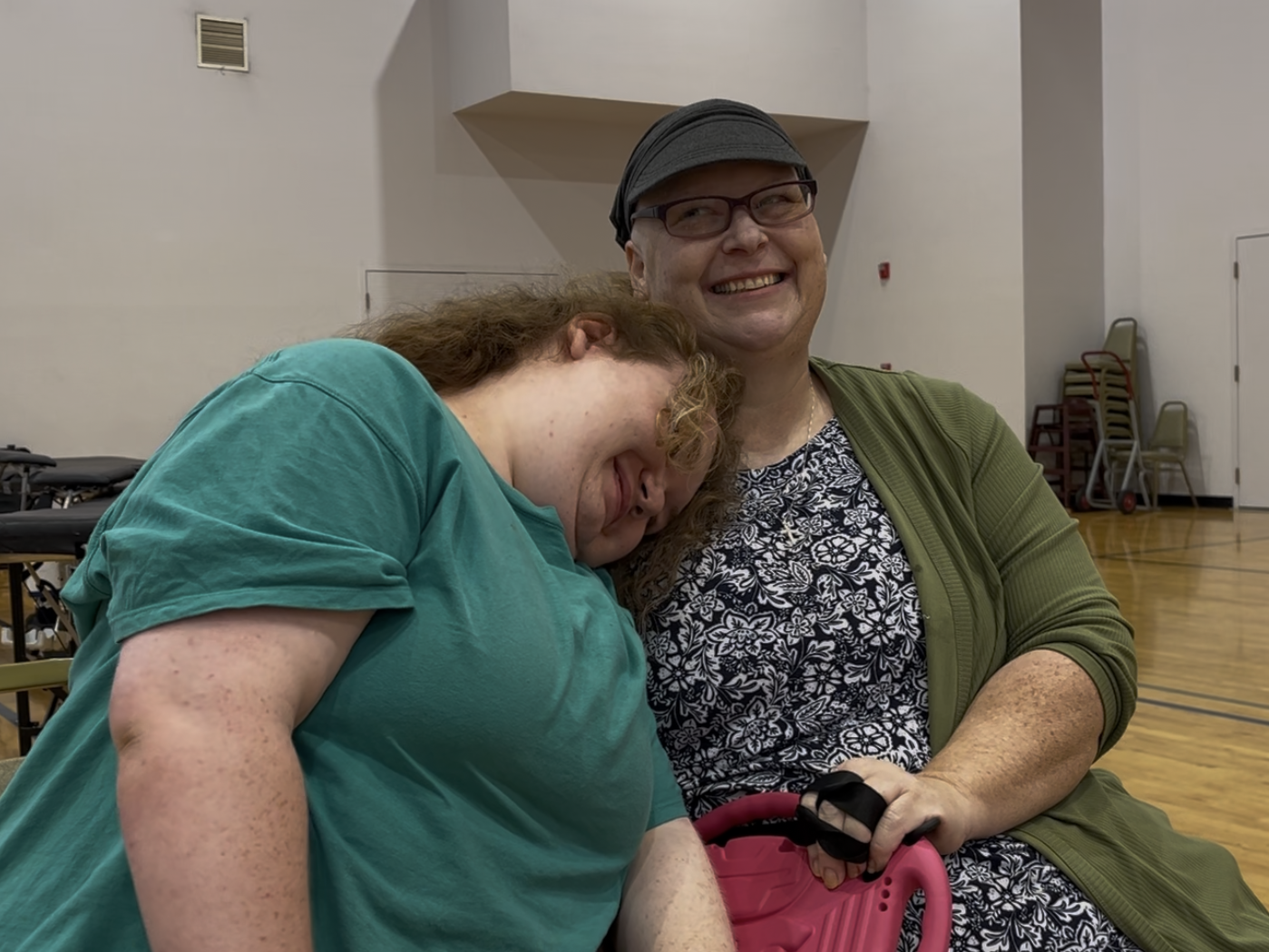 Mom smiles as daughter rests her head on her mom's shoulder.